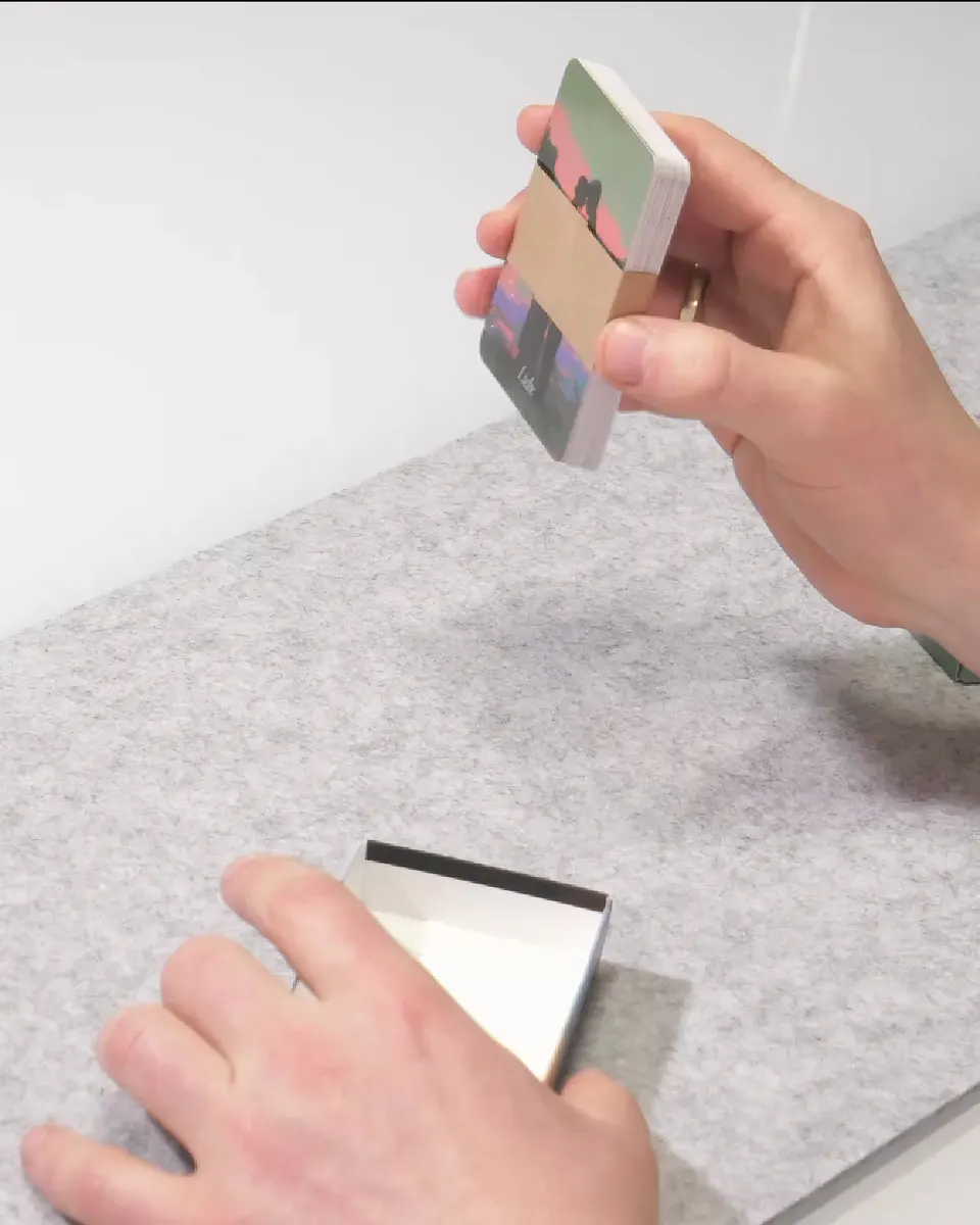 An opened BlickWinkel card deck with the paper-wrapped stack