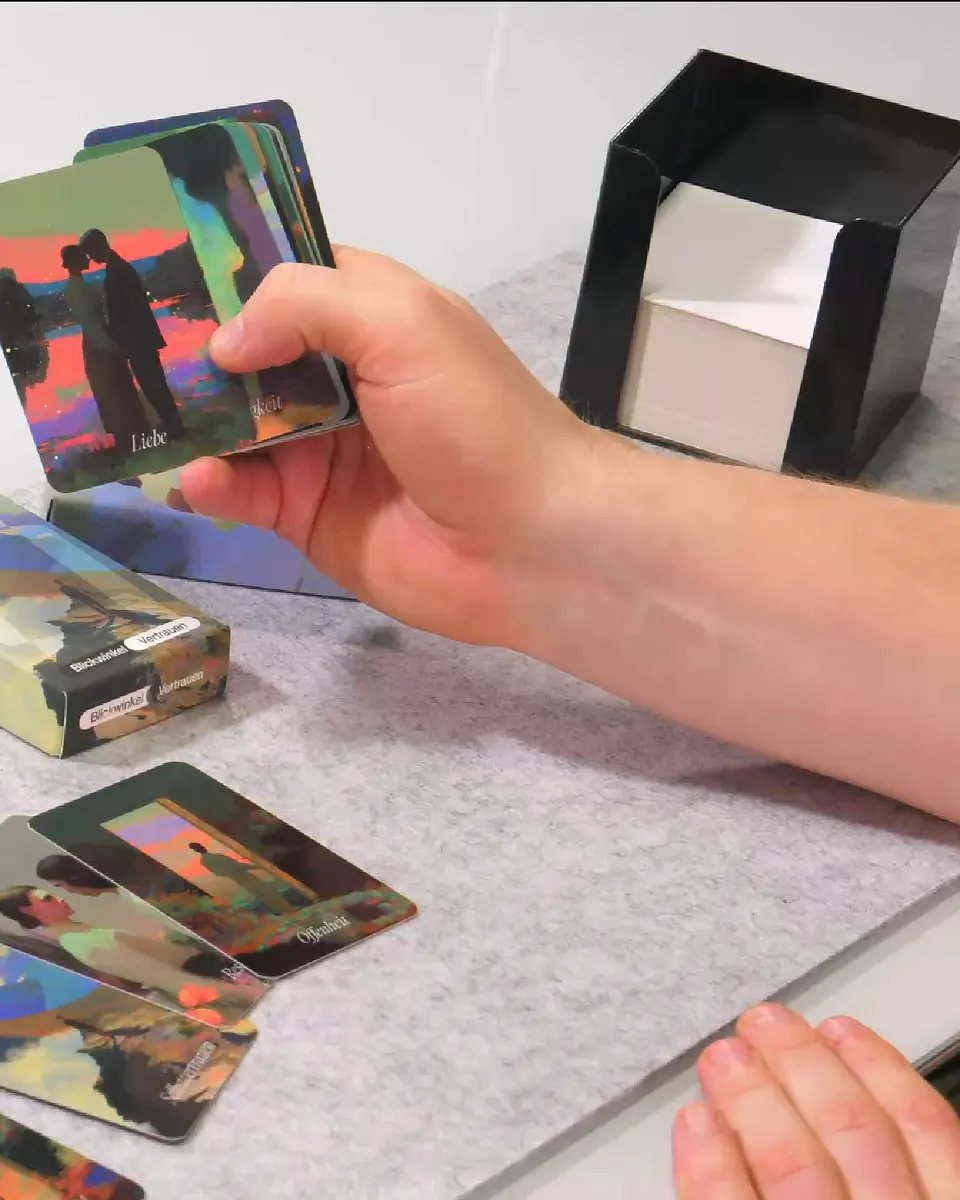 BlickWinkel cards being browsed and held up in a pair of hands