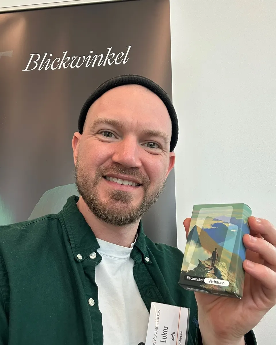 Lukas Rieder holds the BlickWinkel card deck up to the camera